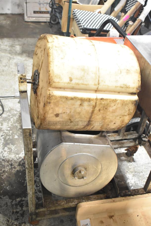 Commercial floor style unit with metal frame and cylindrical components, showing signs of use and wear.