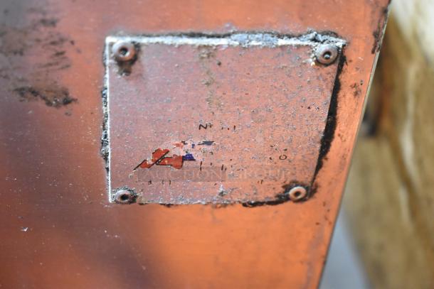 Rusty commercial floor unit with a faded label, indicating wear and age. Screws visible, showing previous use.