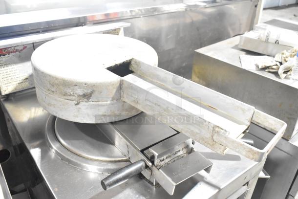 Commercial floor-style pressure fryer, stainless steel, used condition, visible signs of wear, includes operational instructions on unit.