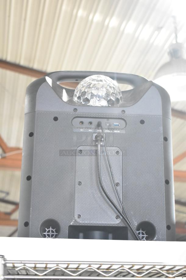 Party Rocker Max Speaker, black, with disco light on top. Features multiple input ports, including USB and AUX.