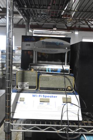 Two Onn Wi-Fi speakers with brass accents, IP67 rating, 20W RMS output, on display shelf. Price tag showing $43.37.
