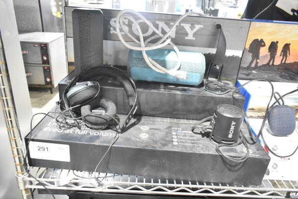 Sony display with speakers, headphones, and Onn speakers on shelf. Includes visible Sony branding and product packaging.