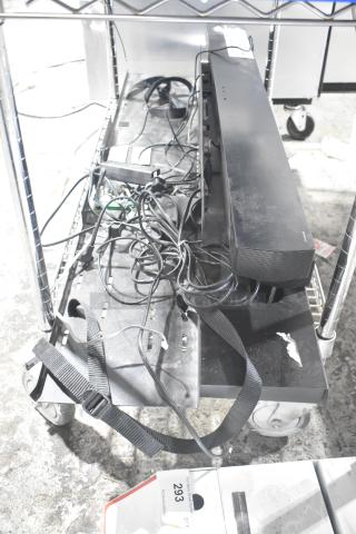 Metal display rack with two shelves, attached wheels, and scattered cables. Visible sticker reads "293" indicating item ID.