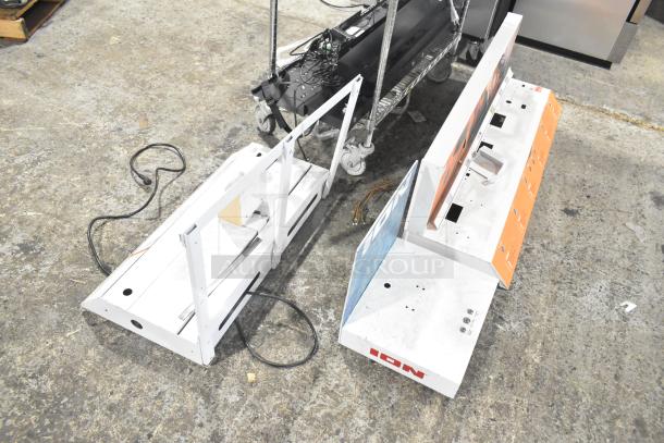 Three white display stands, marked "ION," with graphics on one side. Used condition, visible wiring and mounting holes.
