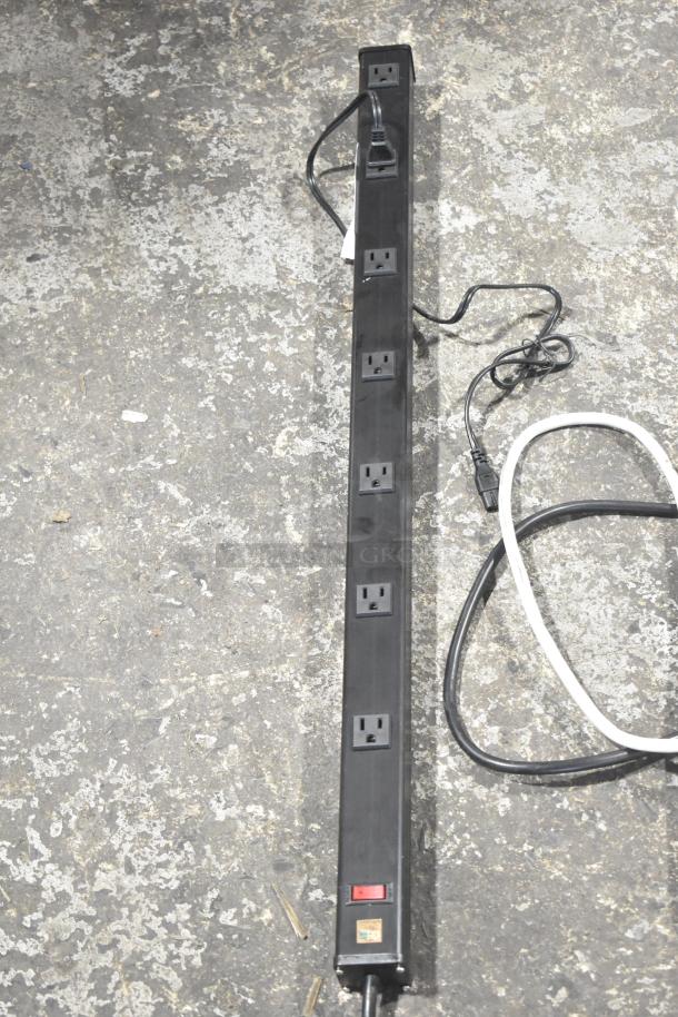 Black power strip with six outlets and a red switch, moderate wear. Includes attached plug. Second strip included.