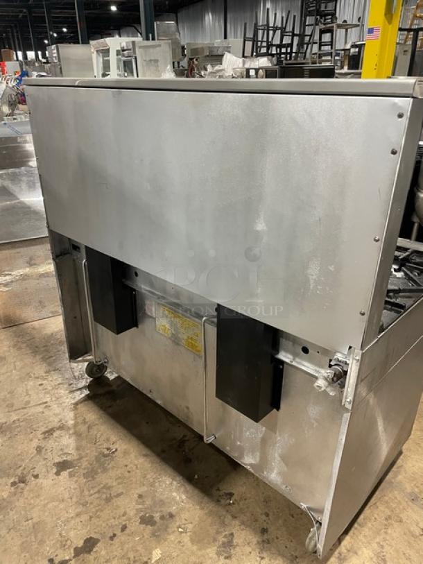 Garland H284 stainless steel gas range, 10 burners, double oven, backsplash, wired rack, on casters, good condition.