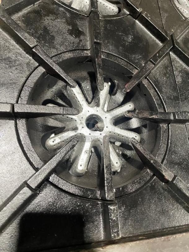 Garland H284 commercial stainless steel 10-burner range close-up, showing cast iron burner grate and cooking surface.