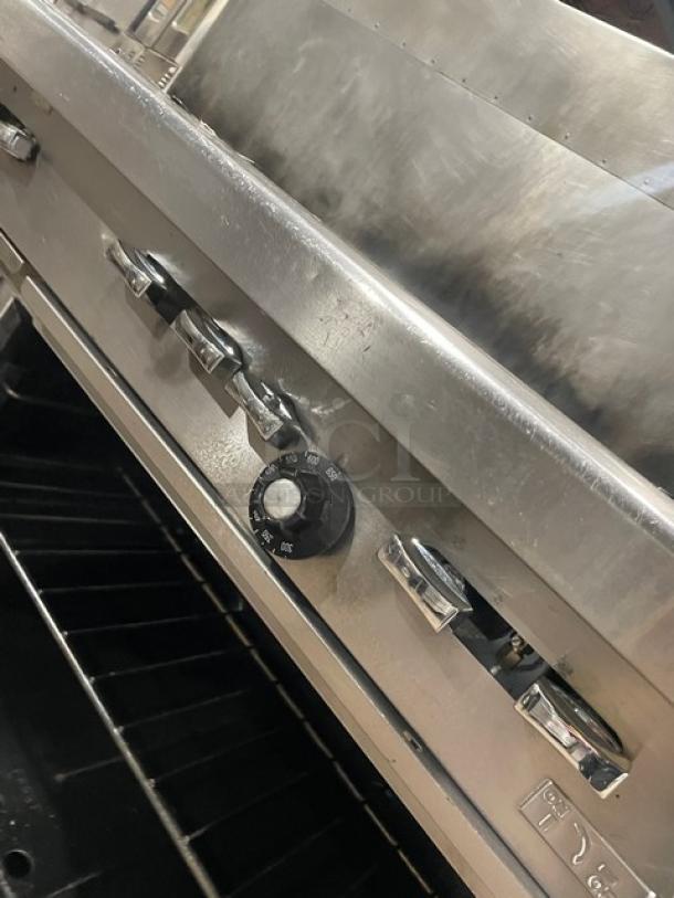 Garland H284 stainless steel range with 10 burners, double oven, and backsplash. Includes wired oven rack; on casters.