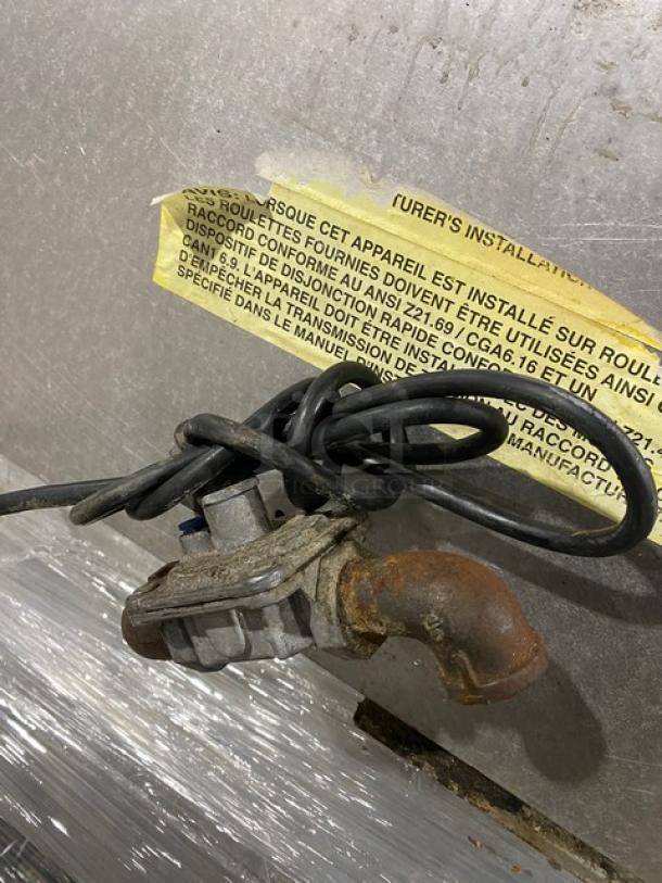 Garland stainless steel gas-powered griddle with thermostatic control. Back and side splash. Power cord and regulator visible.