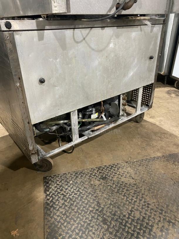 True Commercial Stainless Steel 2-Door 48" Worktop Refrigerator, Model TUC-48, visible wear, on casters, poly-coated rack.