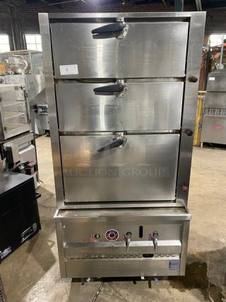 Commercial stainless steel gas-powered 3-compartment seafood steamer with individual controls, wired oven rack, on legs.