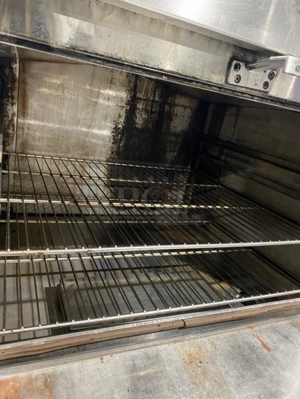 Commercial stainless steel 3-compartment seafood steamer with wired oven rack, individual controls, on legs, used condition.