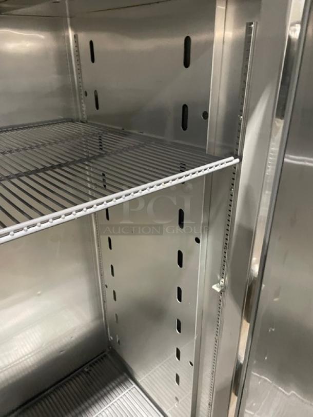 True STG2R commercial refrigerator interior, stainless steel, poly coated wire racks, Energy Star certified, on casters.
