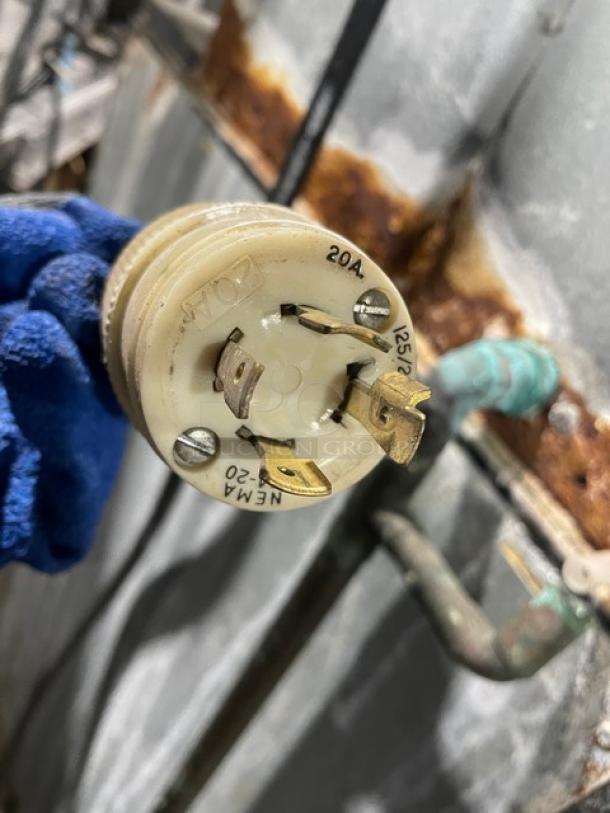 Close-up of a plug labeled "20A, 125V, NEMA 5-20" against a metal background.