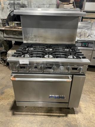 Imperial commercial stainless steel 6-burner range/oven combo, natural gas, with overhead salamander shelf, backsplash, and wired oven rack.
