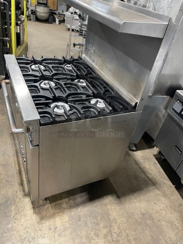 Imperial commercial stainless steel 6-burner range with oven, overhead salamander shelf, and backsplash. Natural gas, includes wired oven rack.