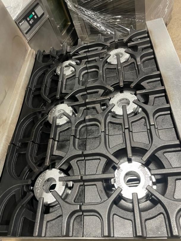 Imperial commercial stainless steel 6-burner range/oven combo with overhead salamander shelf, backsplash, and wired oven rack.