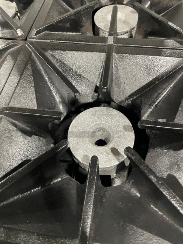 Southbend S241E 4-burner range close-up, showing sturdy black cast iron grates, part of commercial stainless steel combo.