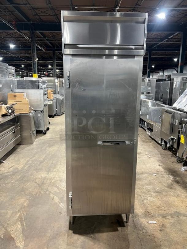 Continental DL1REPT stainless steel single door pass-thru refrigerator, with built-in pan slide, on legs.