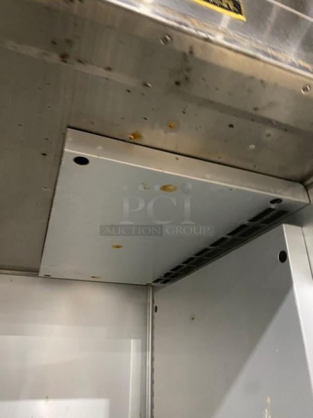 Traulsen stainless steel single section reach-in refrigerator, model AHT132DUT-HHS. Interior wired racks, casters, 115V. Visible wear.