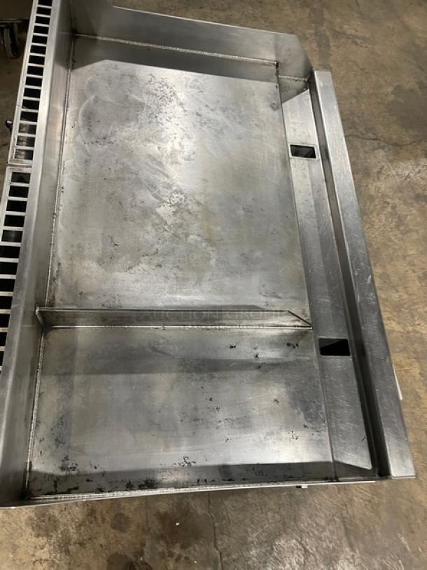 WoodStone stainless steel gas-powered countertop split-top plancha griddle, featuring back and side splash, on legs, used condition.