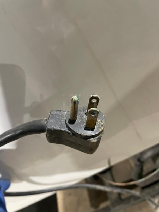 Close-up of a power plug for the True GDM-41 Merchandiser Refrigerator. Plug shows signs of wear and corrosion.
