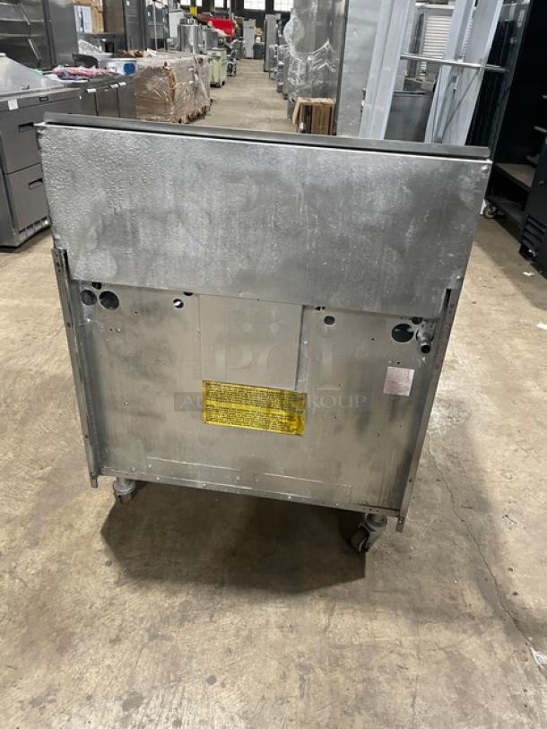 U.S. Range commercial stainless steel 6-burner gas range, with backsplash and enclosed dry cabinet-style storage base, on casters.