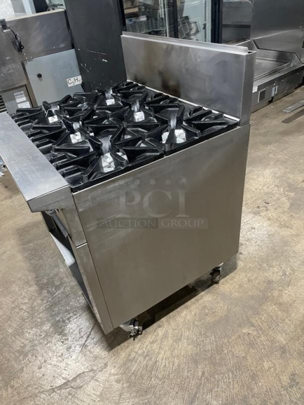 Commercial stainless steel gas-powered 6-burner range by U.S. Range, with backsplash, dry cabinet-style storage, on casters.