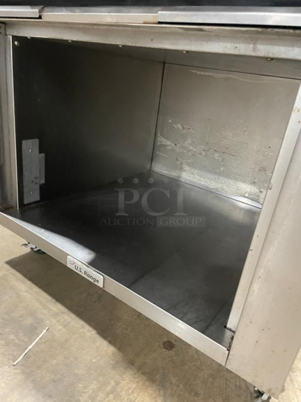 U.S. Range commercial stainless steel gas-powered 6-burner range with backsplash, enclosed storage base, on casters.