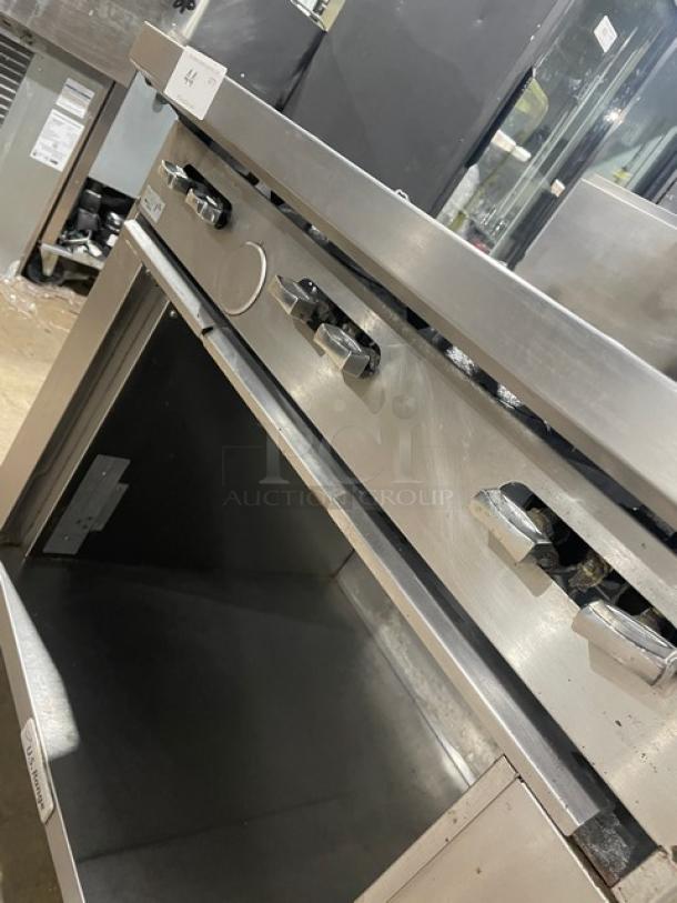 U.S. Range commercial stainless steel 6-burner gas range with backsplash, storage base, and casters. Enclosed dry cabinet.