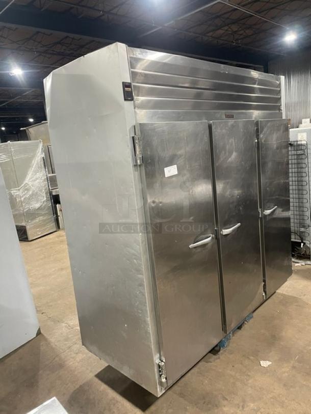 Traulsen G31010 triple door stainless steel freezer, Energy Star certified, with poly coated racks, on casters, model and serial labels visible.