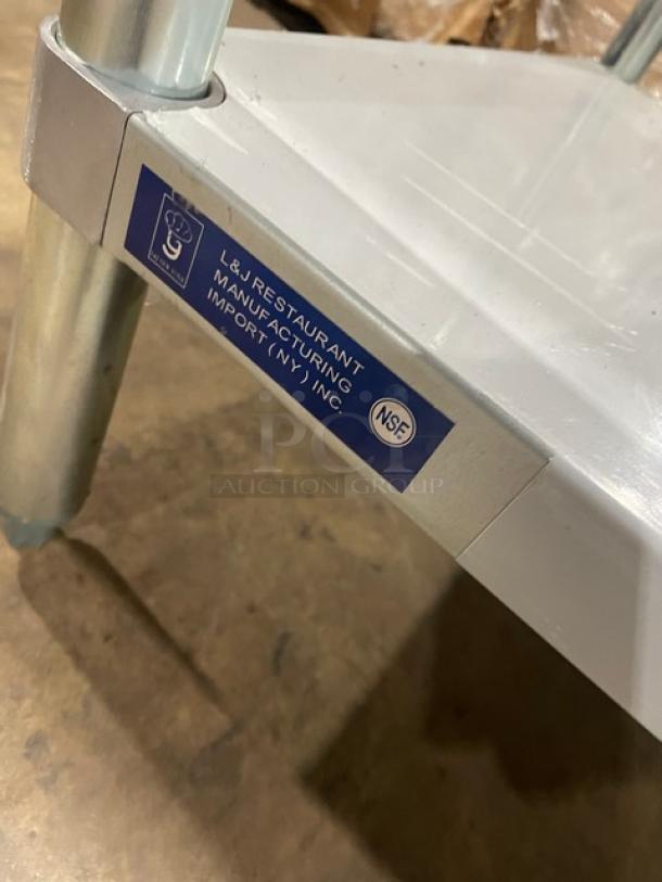 L&J stainless steel worktop table, scratch-n-dent, single undershelf, on legs. "L&J Restaurant Manufacturing Import (NY) Inc." label visible.