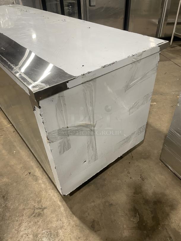 Custom Cool stainless steel 3-door refrigerated worktop table, model LB93SC, in like-new condition with a universal pan rack, on casters.