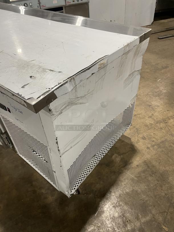 Custom Cool stainless steel 3-door refrigerated worktop table with built-in pan rack, model LB93SC. Like new condition, on casters.