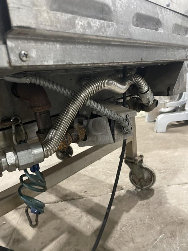 Lang 224TH-NATMG stainless steel natural gas infrared griddle on casters. Visible gas connections, equipment stand, and cart.