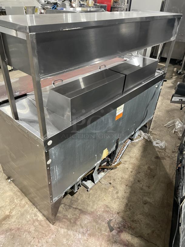 Delfield stainless steel 4-drawer refrigerated prep table UCD4464N12DD5 with overhead salamander storage and cutting board.