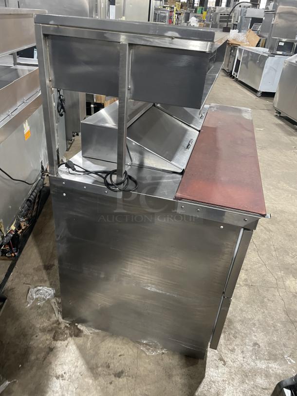 Delfield UCD4464N12DD5 stainless steel refrigerated prep table with 4 drawers, overhead storage, cutting board, 115V.