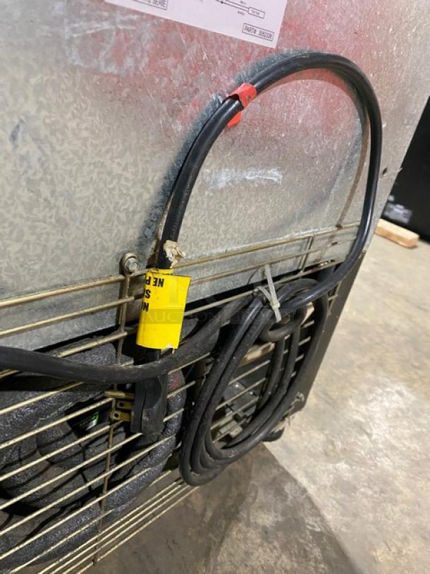 Imbera VR12R2 commercial cooler back view with wires, metal casing, and label. Features poly-coated wire rack and casters.