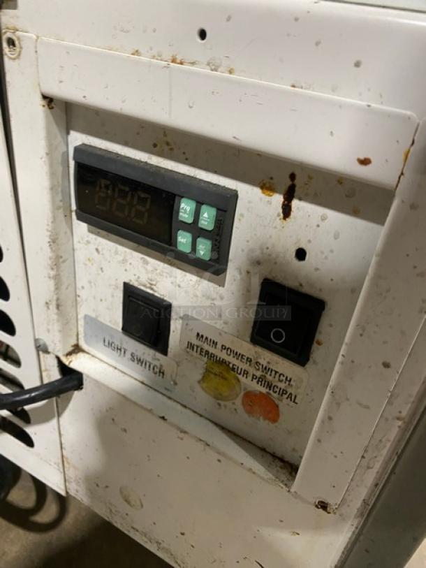 Control panel of Structural Concepts HV38R refrigerated bakery display case, featuring power and light switches with visible wear.