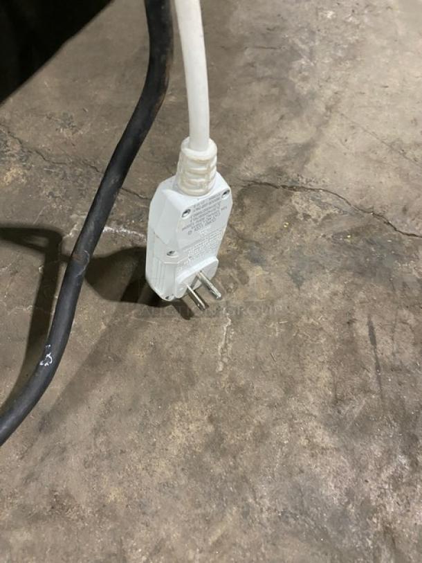 ORCA food waste digester plug on concrete floor, featuring a standard 120V electric cord.