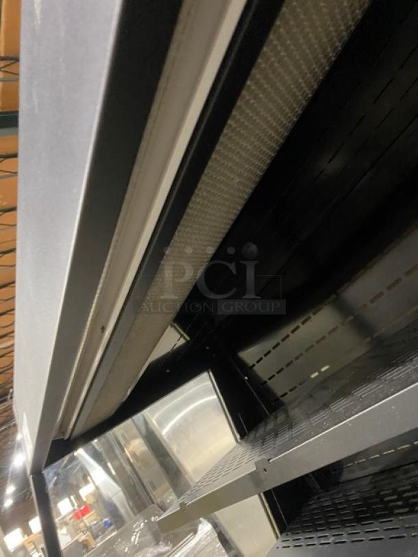 Kool-It KOM36XBK black open merchandiser case with adjustable shelving, displays commercial use wear, on legs, 110-120V.