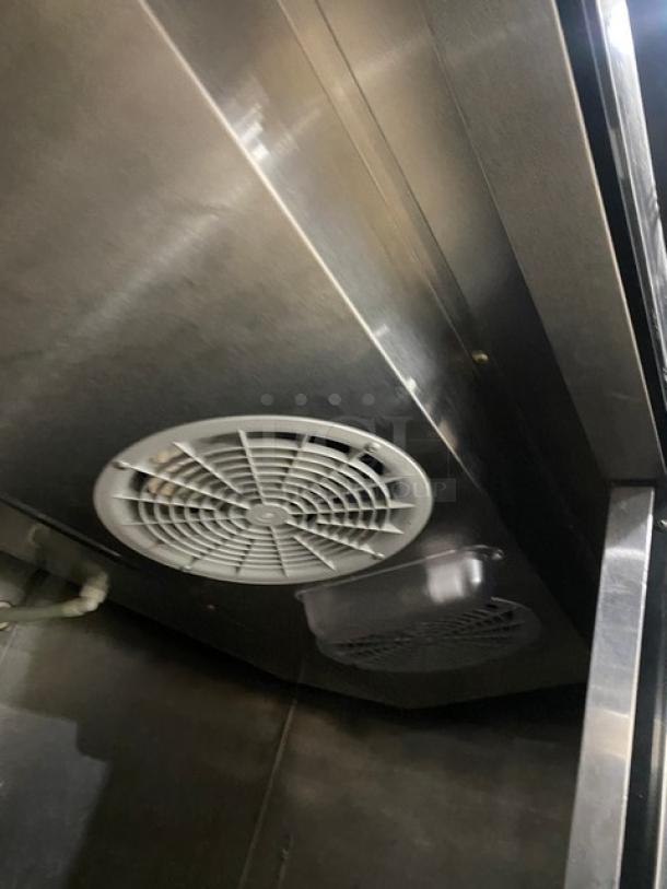 Migali C2R commercial stainless steel 2-door reach-in refrigerator, interior view showing fan and stainless surfaces.