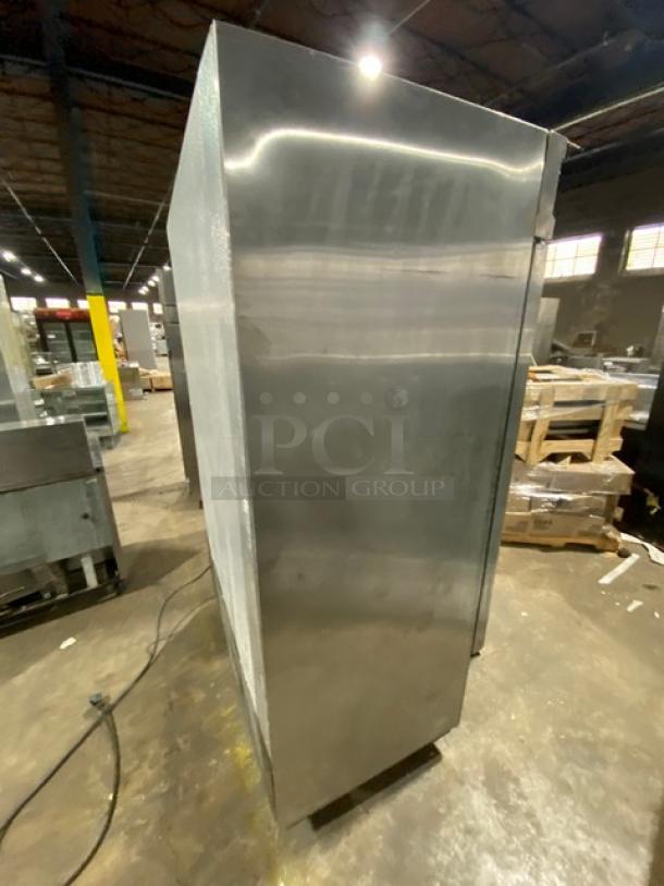 Economy EF2 stainless steel 2-door freezer, Energy Star certified, poly coated rack, on casters, side view in warehouse.