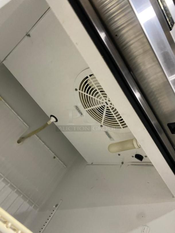 True T-23F-2 commercial stainless steel freezer interior, with poly-coated wired rack and fan, on casters.