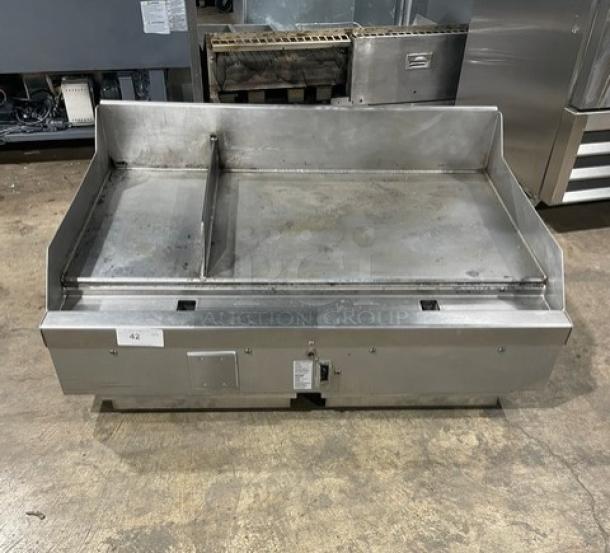 WoodStone stainless steel gas countertop split-top plancha griddle with back and side splash, on legs. Visible label indicates model details.