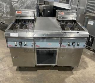 Pitco Frialator 2-Bay Deep Fat Fryer System, stainless steel, with center pan cabinet, splashback, basket hanger, on casters.