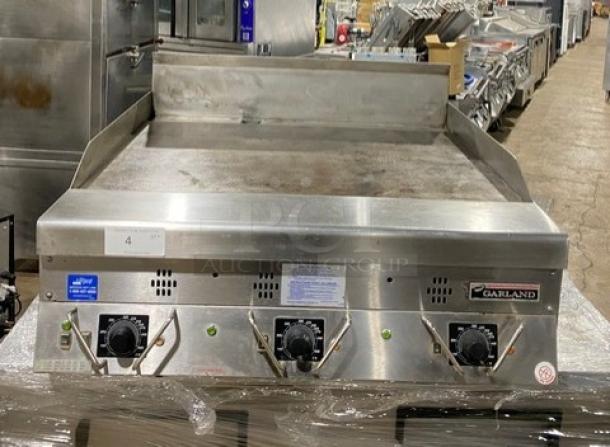 Garland commercial stainless steel gas griddle with back and side splash, thermostatic control, excellent condition.