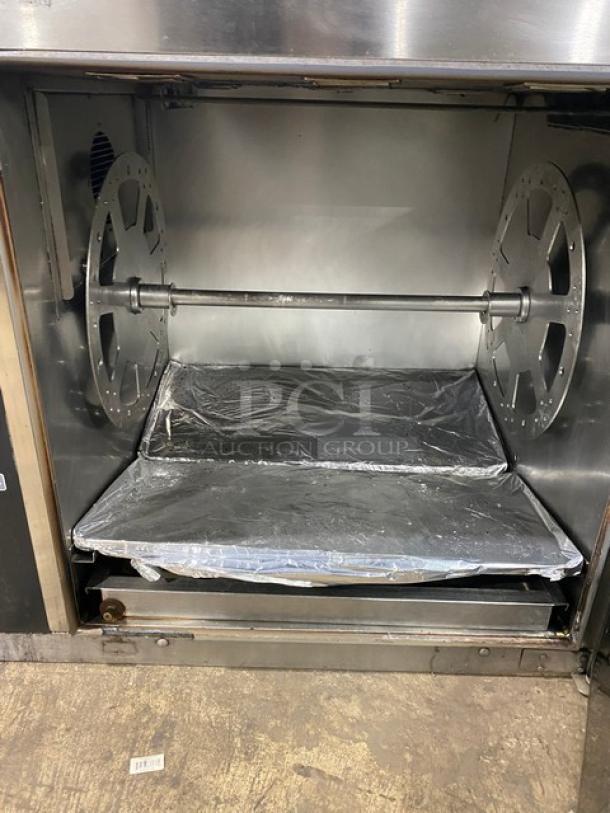 Alto-Shaam stainless steel electric countertop rotisserie oven with digital controls, showing open interior.