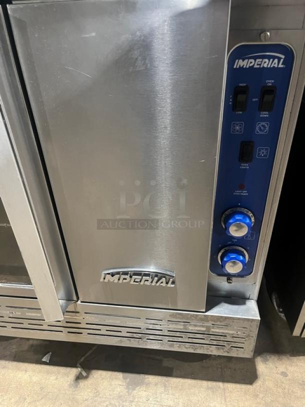 Imperial stainless steel double stacked convection oven, natural gas-powered, with wired oven rack and caster wheels.