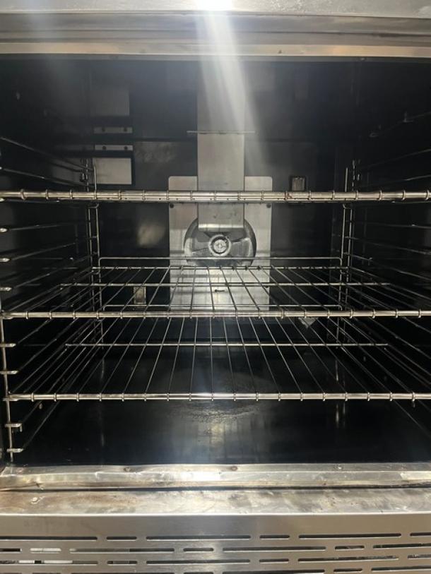 Imperial double stacked stainless steel convection oven, natural gas powered, with wired rack, on casters, unused condition.